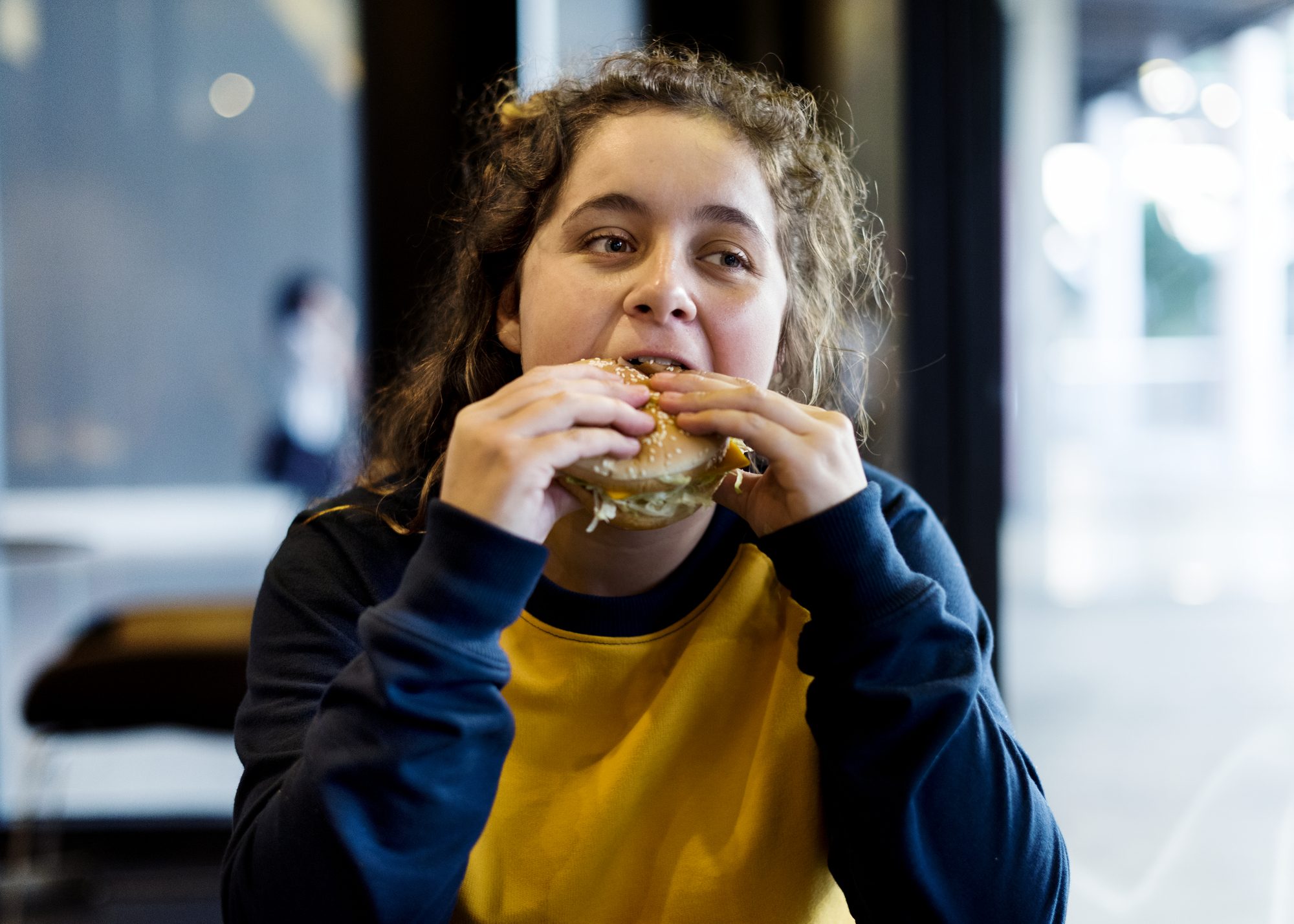 close-up-of-teenage-girl-eating-hamburger-obesity--PXWZT96