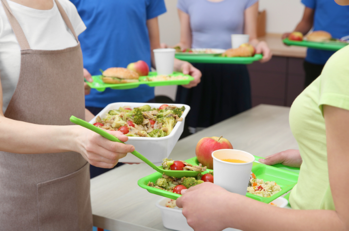 school-staff-adding-healthy-food-to-lunch-plate
