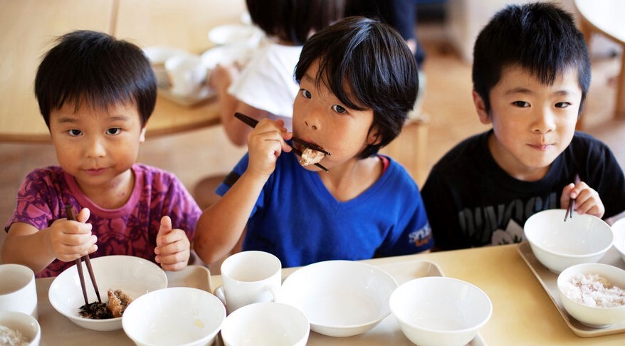 High-angle-view-of-three-boys-sitting-at-a-table-eating-lunch